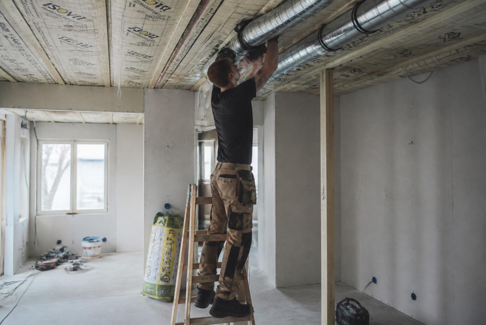 Montør monterer ventilationskanaler under renovering